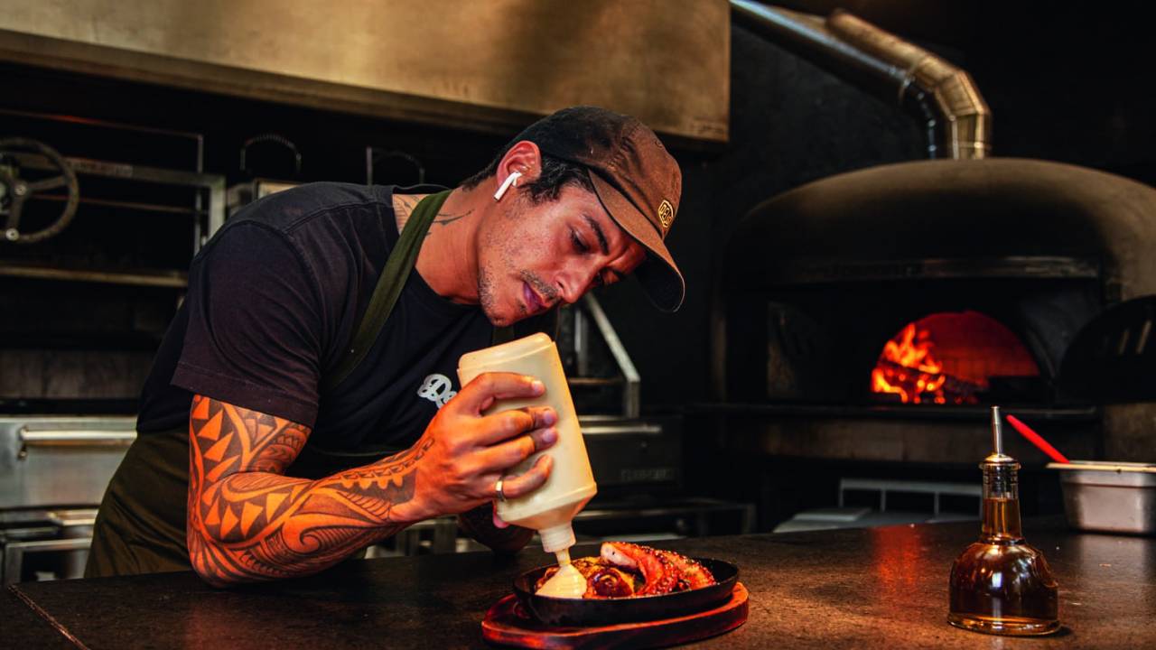 Dário finaliza um prato no balcão do restaurante