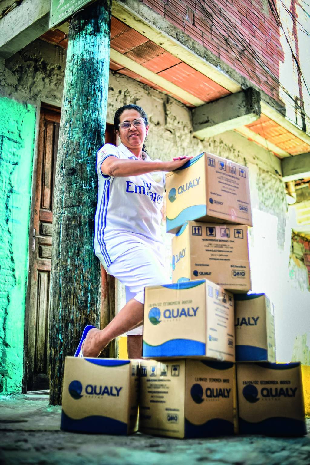 NEIDE_FAVELAFLAMENGO_3.JPG Imagem mostra mulher de roupa branca com caixas de papelão