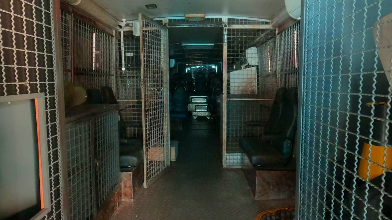 Foto mostra interior de um ônibus cenográfico escuro, com aparência de assombrado
