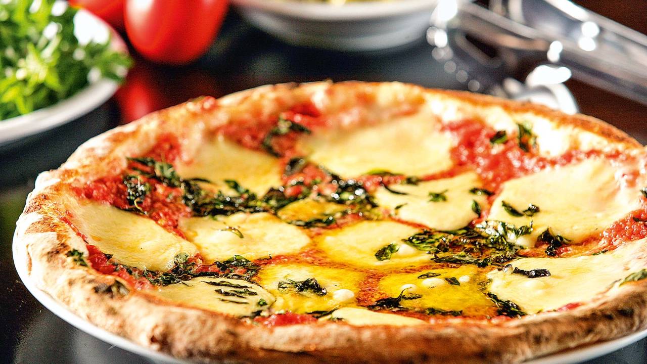 Disco de pizza com cobertura sabor margherita fotografado a partir de uma visão lateral
