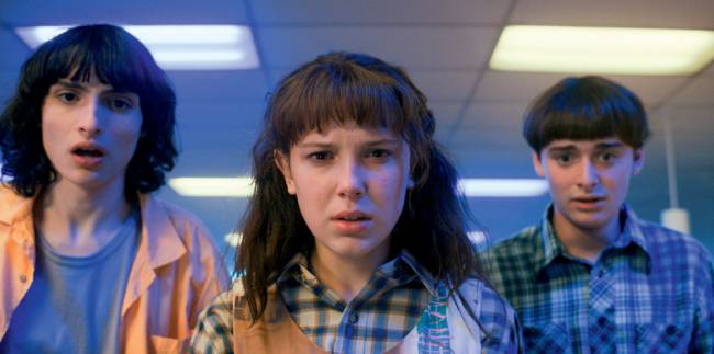 stranger things – credito netflix.jpg Imagem mostra três jovens olhando para a câmera, com caras de assustados.