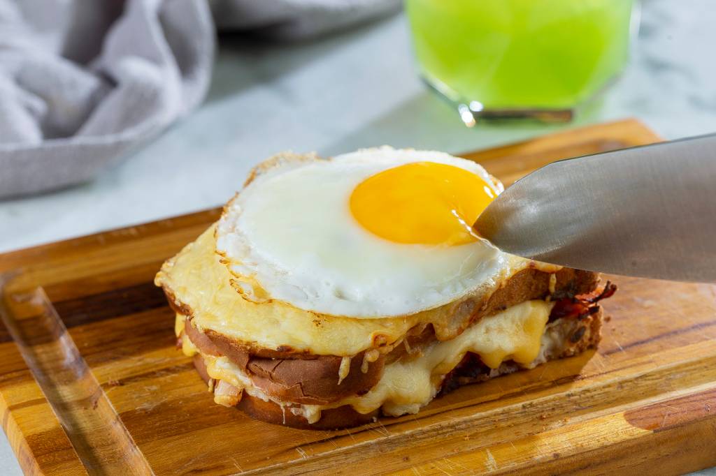 Croque madame servido sobre tábua de madeira