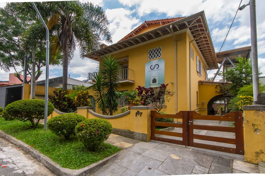Casa Guilherme de Almeida Casa Guilherme de Almeida, uma casa antiga amarela, que tem um jardim na calçada