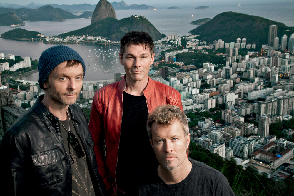 Imagem mostra três homens e o Rio de Janeiro ao fundo.
