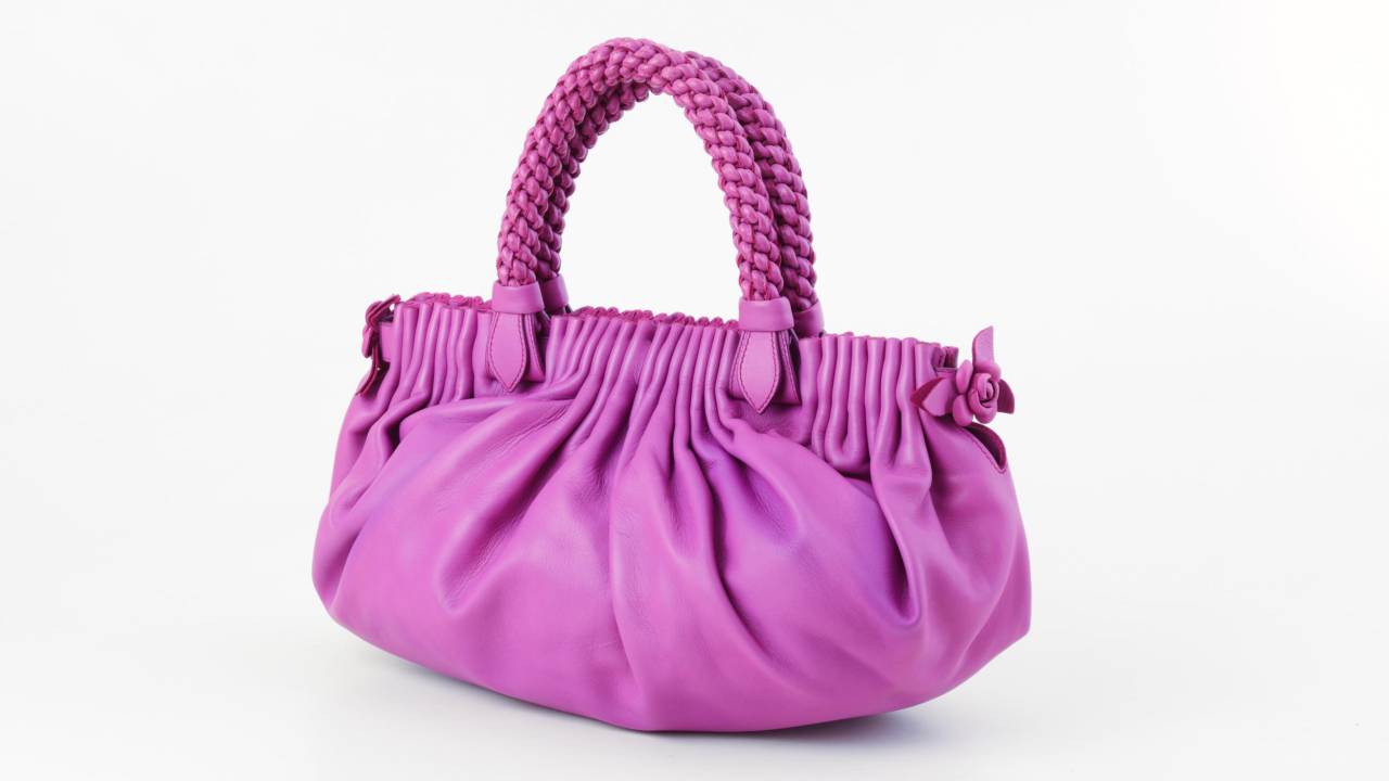 Bolsa com alça na cor rosa.