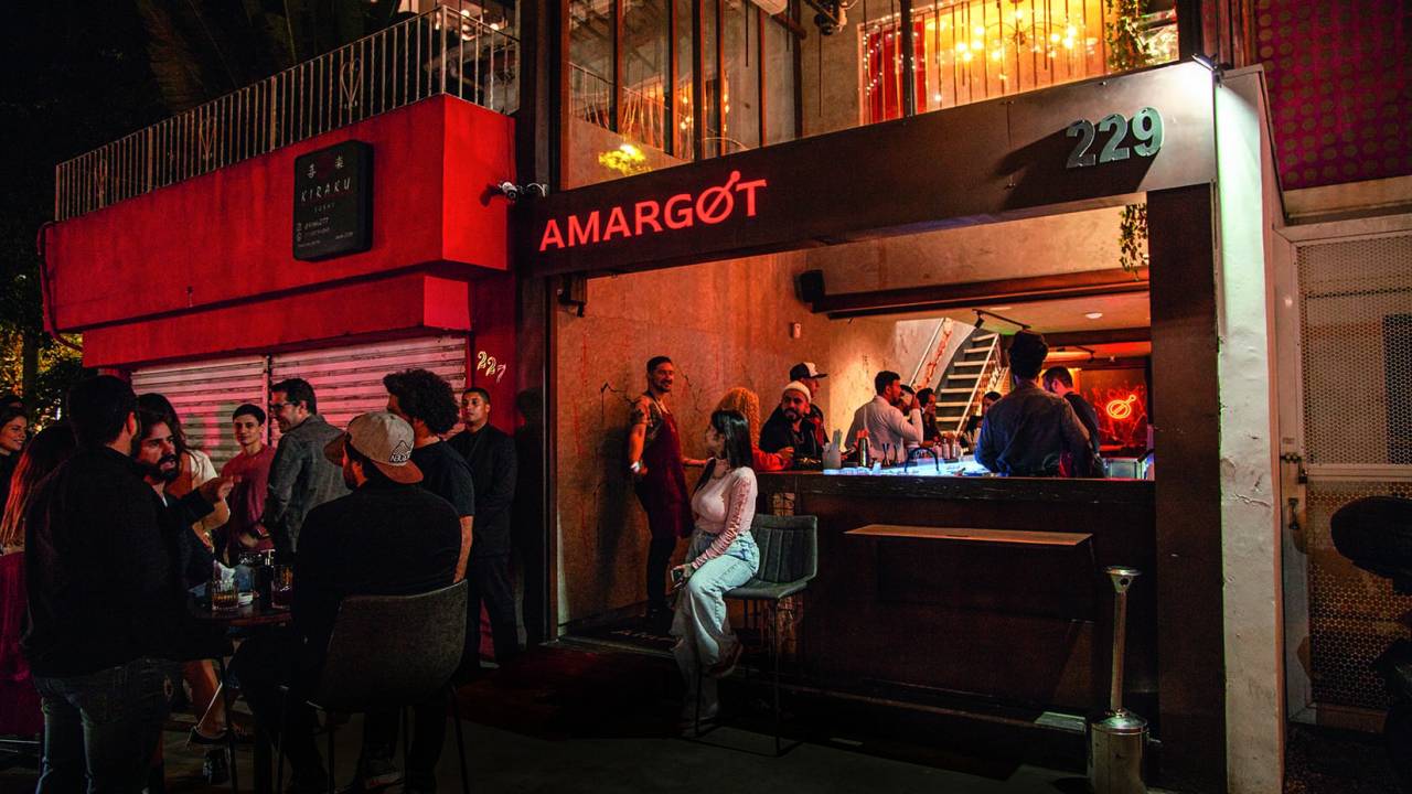 Fachada de bar com pessoas sentadas e em pé conversando.