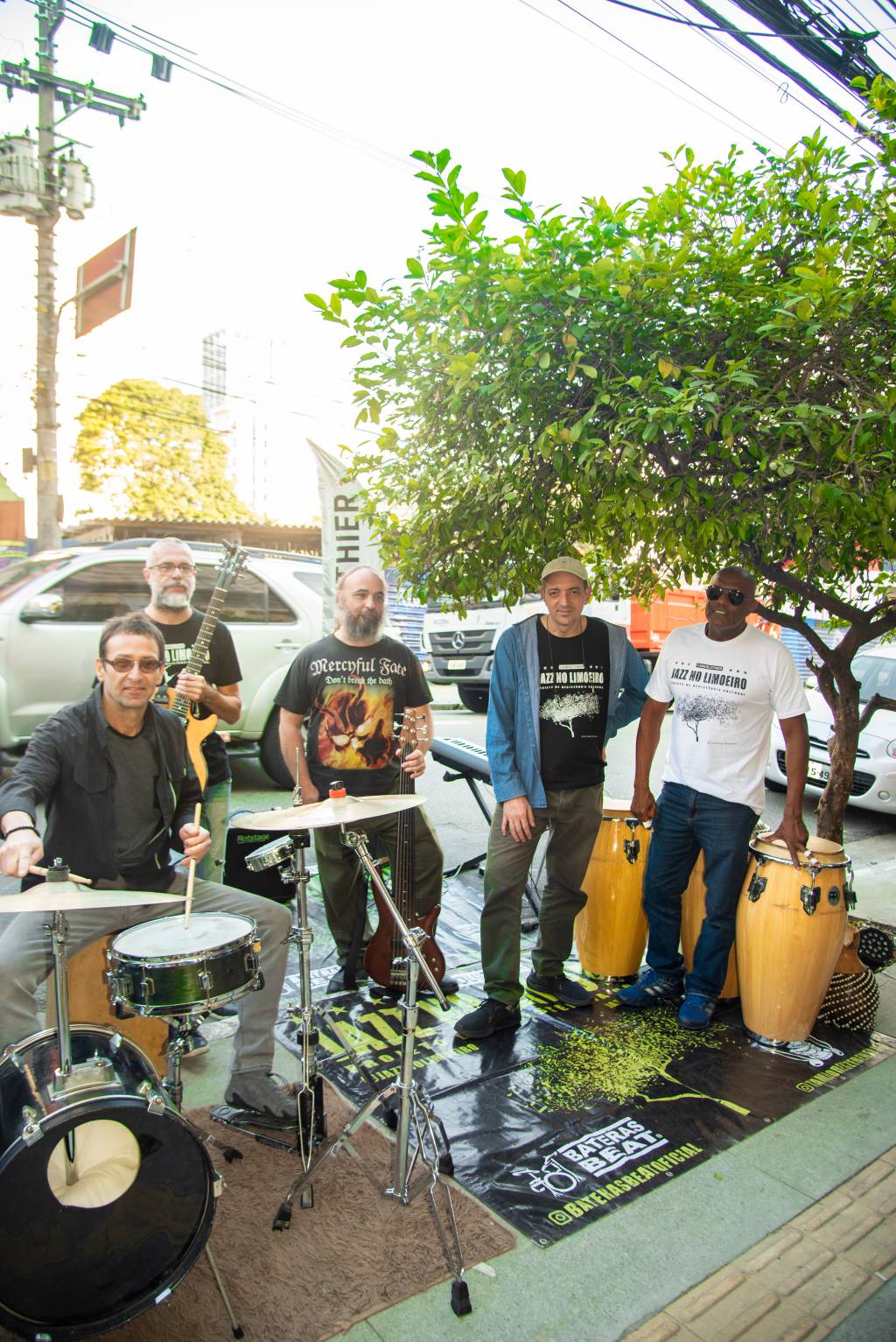 JAZZ NO LIMOEIRO (LIGIA SKOWRONSKI) Cinco homens posam debaixo de pé de limão com instrumentos e carros ao fundo.