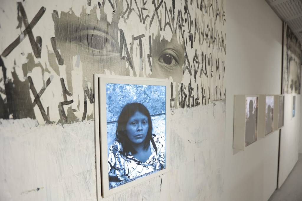 Imagem mostra imagem de mulher indígena em parede branca.