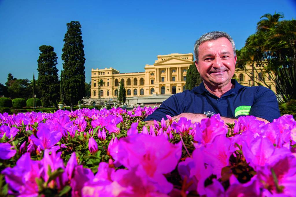 Veja SP Eduardo Funari, paisagista do jardim do Museu do Ipiranga, posa atrás de rosas e com o Museu ao fundo.