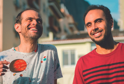 Imagem mostra dois homens sorrindo em dia ensolarado