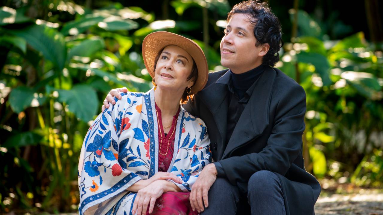 Nívea e Arlindo posam juntos sentados olhando para a esquerda. Ela veste chapéu e xale, ele paletó preto.
