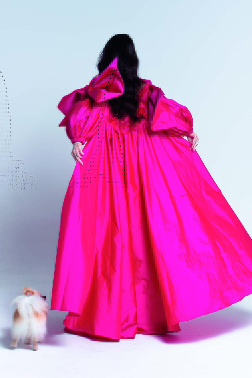 Tia Crey (ALE VIRGÍLIO-DIVULGAÇÃO) (1).jpg Mulher de cabelos pretos posa de costas em longo vestido rosa choque.