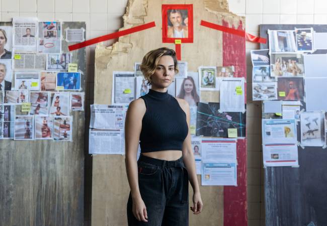 bom dia veronica – credito Laura Campanella Mulher de preto está parada em frente a painel de investigação, repleto de imagens