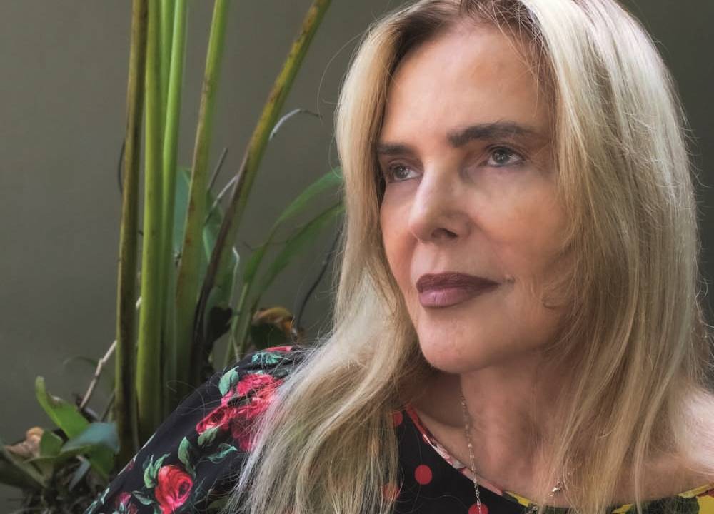 A empresária Laja Zylberman posa olhando para o lado. Tem cabelos loiros longos e lábios com batom amarronzado.