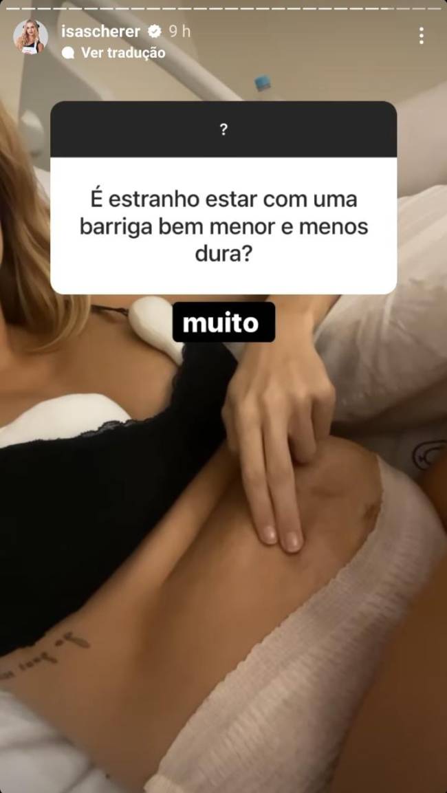 Foto da barriga flácida de Isabella Scherer após o parto, ela pressiona os dedos sobre a barriga