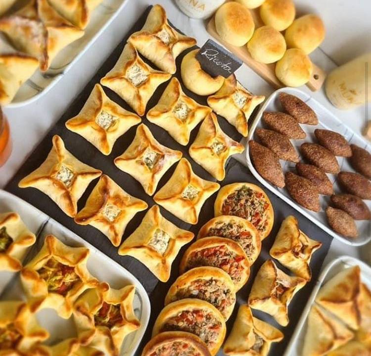 Esfirras, quibes e demais salgados árabes dispostos em uma mesa