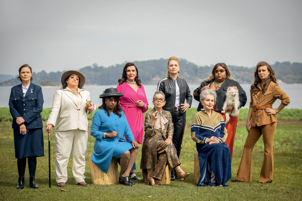 Imagem mostra grupo de mulheres enfileiradas em gramado, com uma represa ao fundo