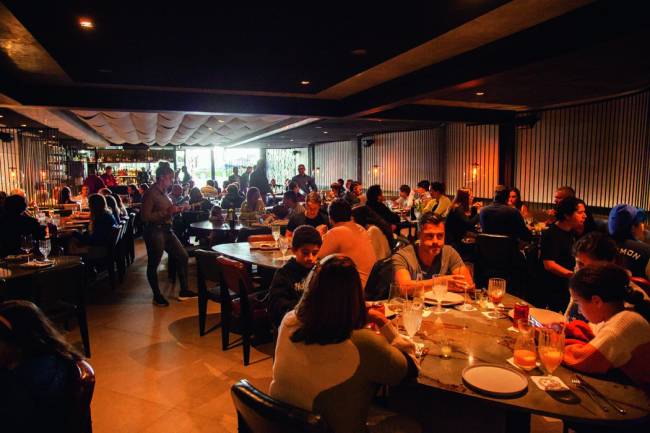 Ambiente interno de restaurante com pessoas à mesa