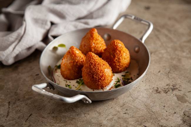 quatro coxinhas em uma panelinha com molho catupiry