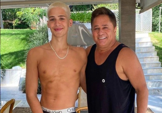 Foto de João Guilherme sem camisa e seu pai, Leonardo, usando regata preta, ambos sorrindo.