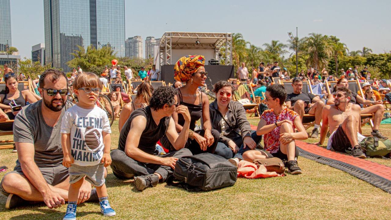 Pessoas sentadas na grama em um dia de sol