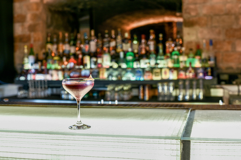 Drinque em taça em cima de balcão do Bar dos Arcos
