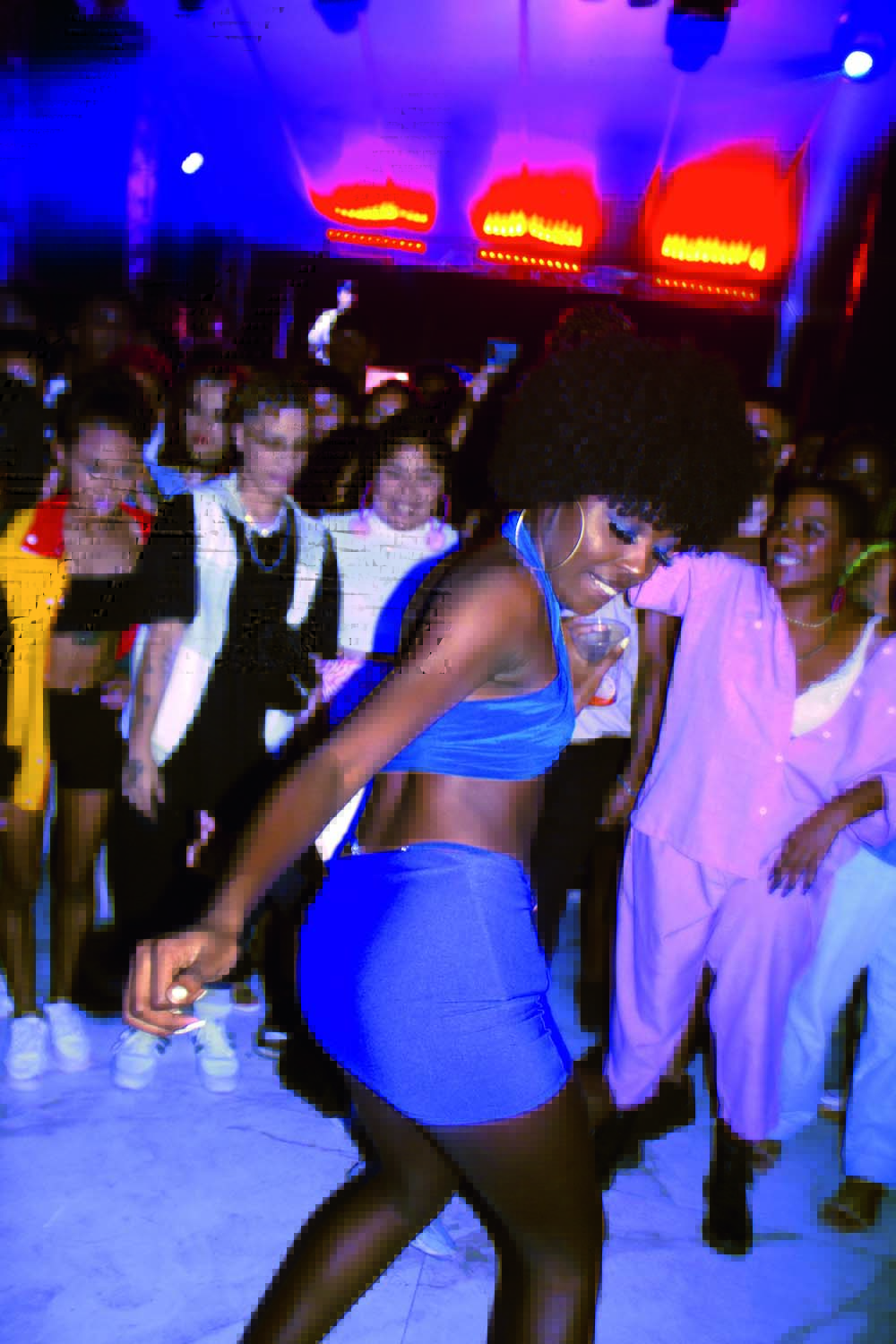 Crédito @trovanine_Divulgação.png Imagem mostra mulher dançando em pista com multidão de pessoas