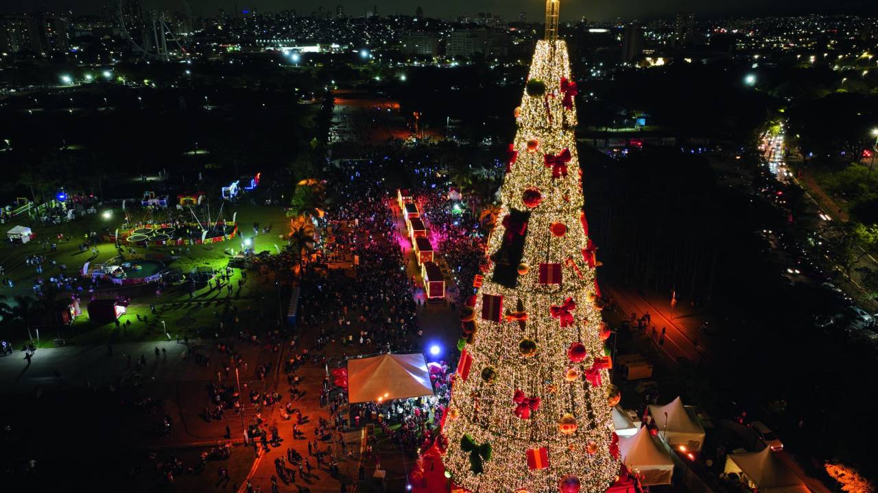 Foto aérea mostra árvore de Natal e fileira de caminhões saindo em direção a rua