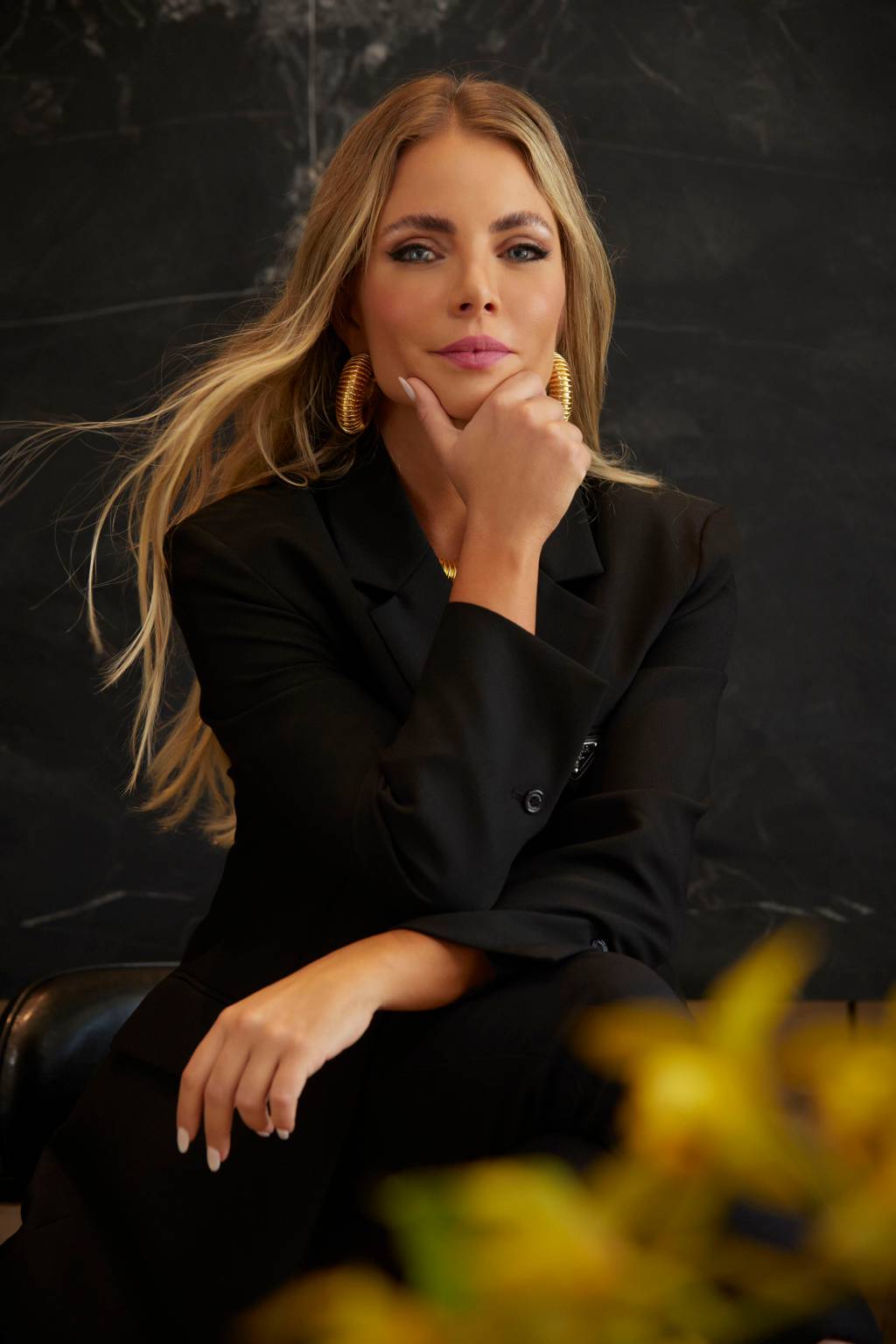 Isa Santini (André Arthur-Divulgação) Empresária Isa Santini posa com cabelos levemente ao vento, loiros, e uma mão apoiada no queixo. Veste blazer preto.