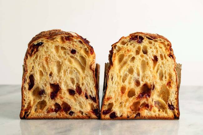 Panetone cortado ao meio com as duas metades lado a lado, a parte do corte voltada para a frente