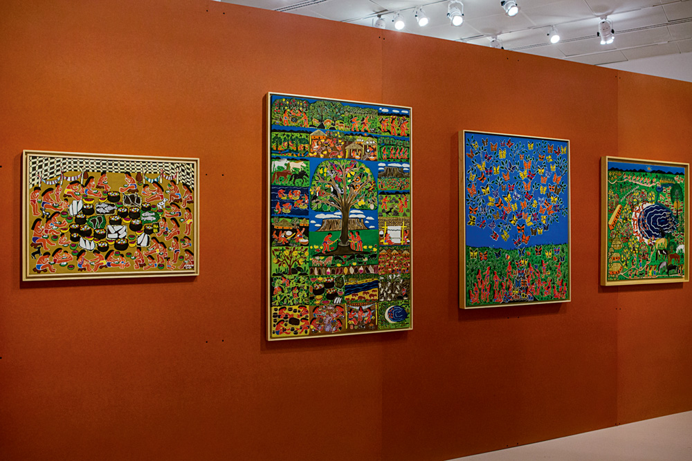 Imagem mostra parede laranja com quadros coloridos
