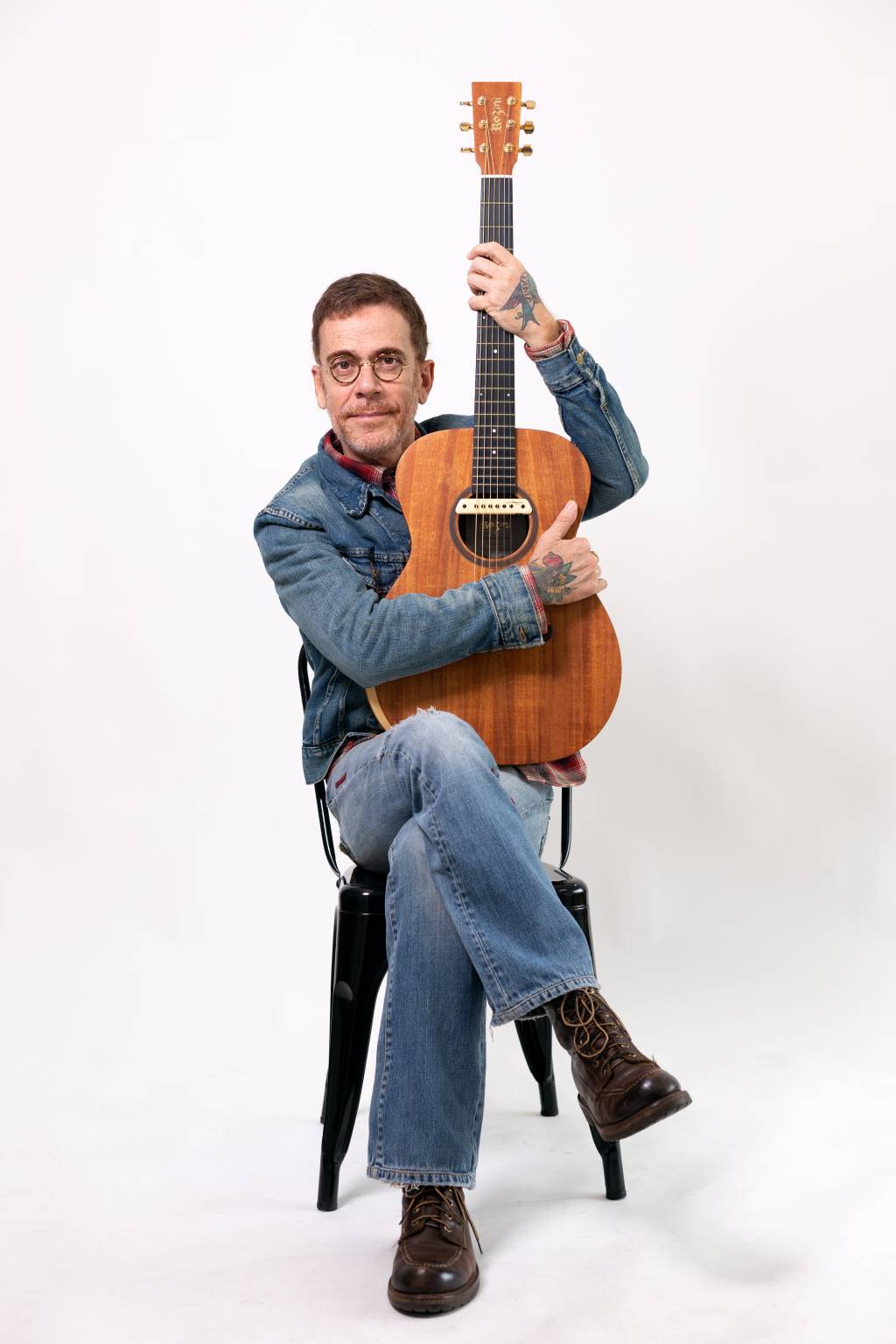 Nando Reis Imagem mostra homem segurando violão