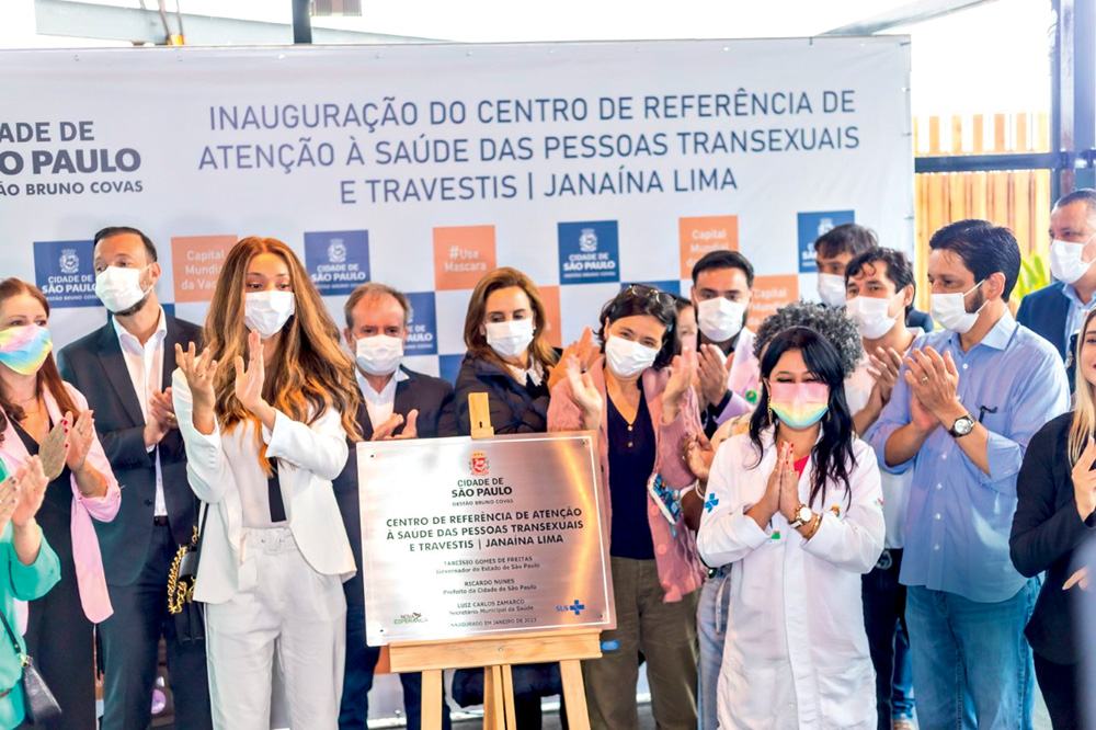 Foto mostra Erika Hilton e Ricardo Nunes, com outras pessoas ao fundo, todos de máscara facial, na inauguração do Centro Janaína Lima