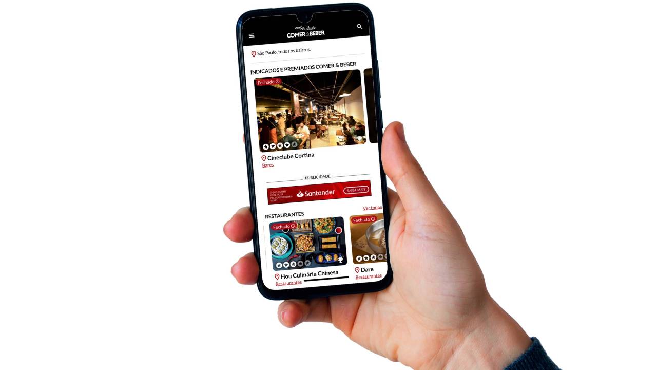 uma mão segura o celular que está com o app na tela do aparelho