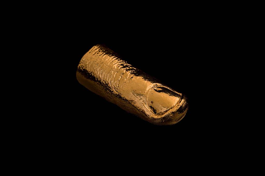 Bruno Baptistelli Imagem mostra dedo dourado sobre fundo preto