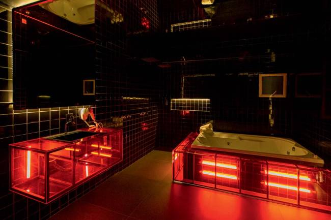 fernandateixeira_09.jpg Foto mostra quarto com paredes pretas e iluminação vermelha