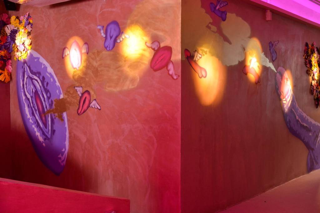 FOTOS PAULO SANTOS. Parede repleta de neons rosados em formato de vulva e pênis.