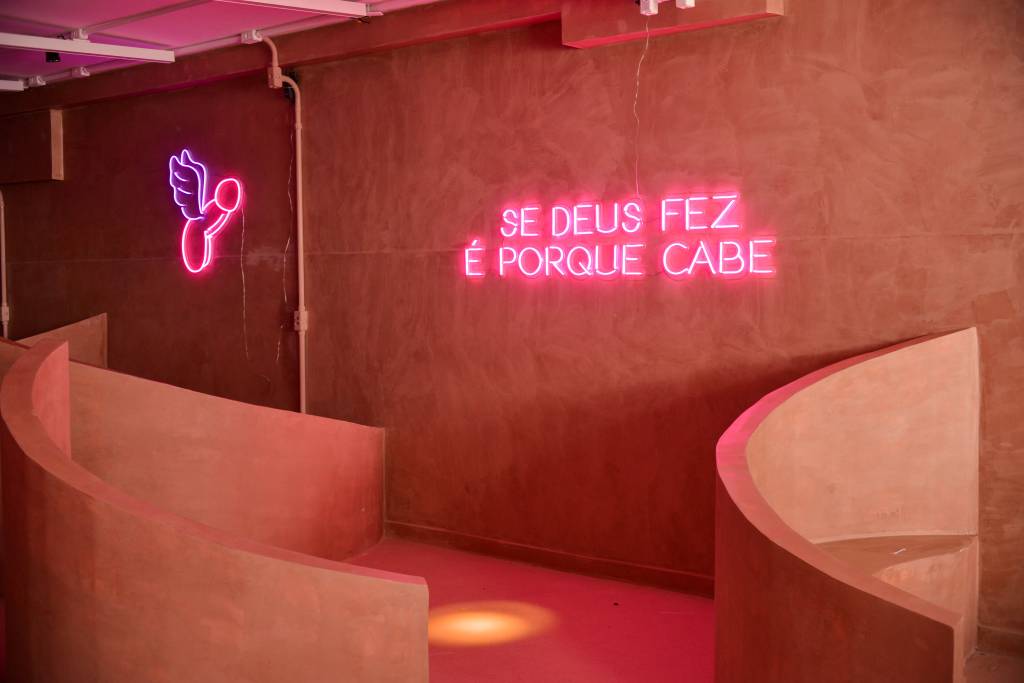 Ambiente rosa com letreiro neon que diz 