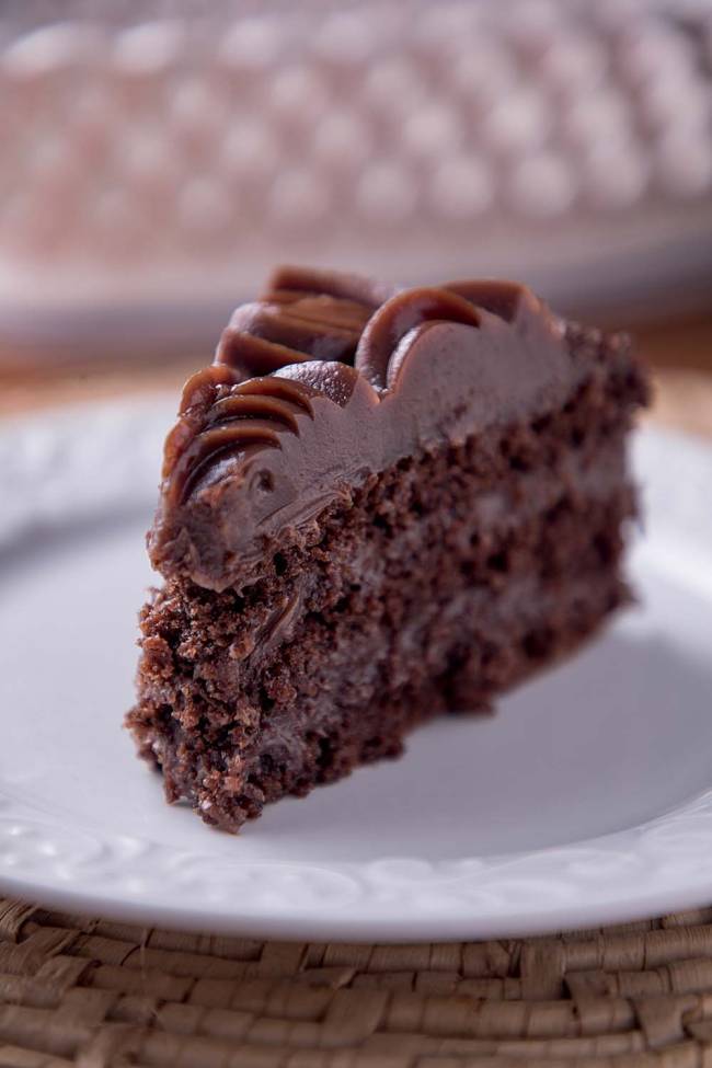 Pedaço de bolo de brigadeiro sobre prato branco de porcelana