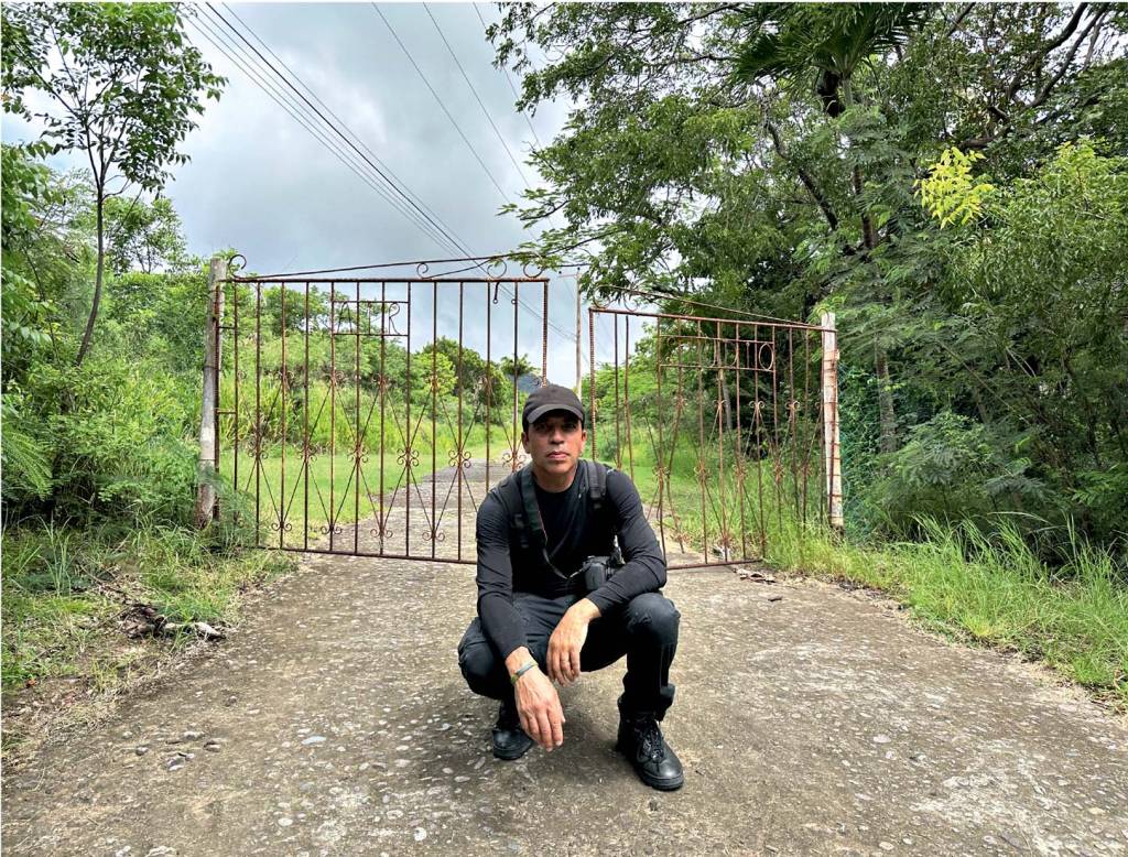 AIR MONTSERRAT Sallaberry Imagem mostra homem de roupas pretas agachado em frente a portão