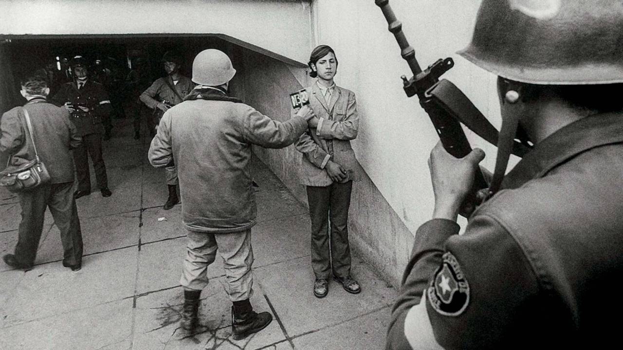 Imagem mostra soldado revistando homem com placa de identificação