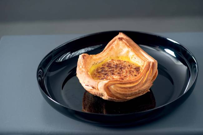 Cesta creme brulée Flipo Café Cestinha folhada com creme brulée sobre prato preto em mesa cinza