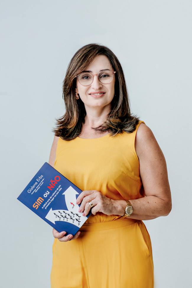 Mulher sorrindo e segurando um livro azul