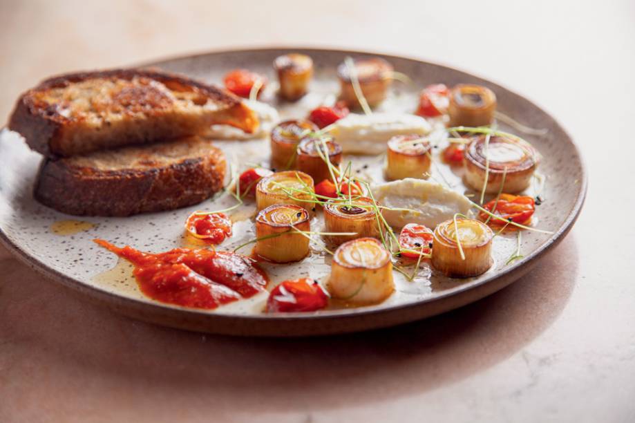 Petisco de alho-poró: servido com queijo de ovelha, tomatinho confitado e molho picante Petisco de alho-poró: servido com queijo de ovelha, tomatinho confitado e molho picante