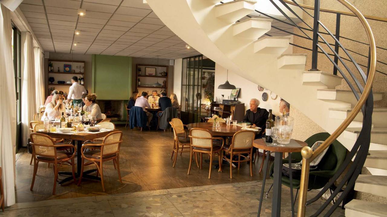 Salão do restaurante Casa Santo Antônio com escada no meio do salão.