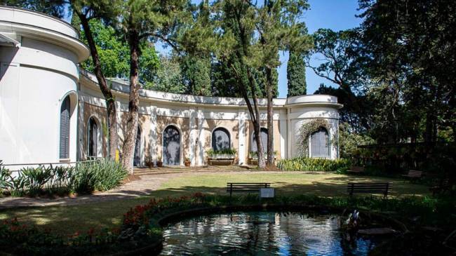 uma casa com fachada antiga e um lago