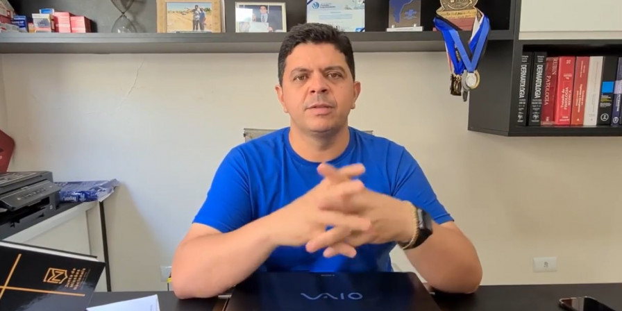 Um homem de camiseta azul cruzando as mãos