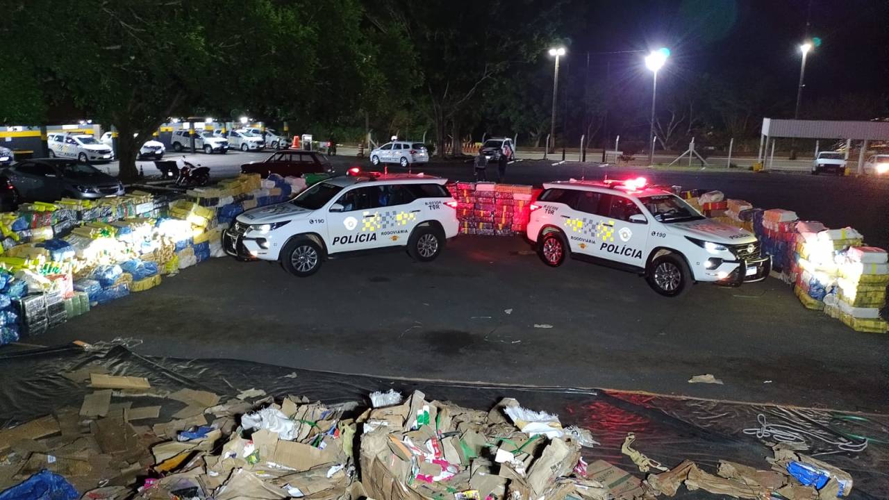 Viaturas da polícia entre tabletes de maconha e papelão rasgado