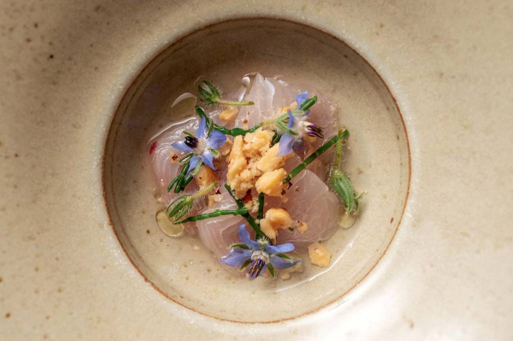 Foto aérea de peixe branco cru com flores lilás.