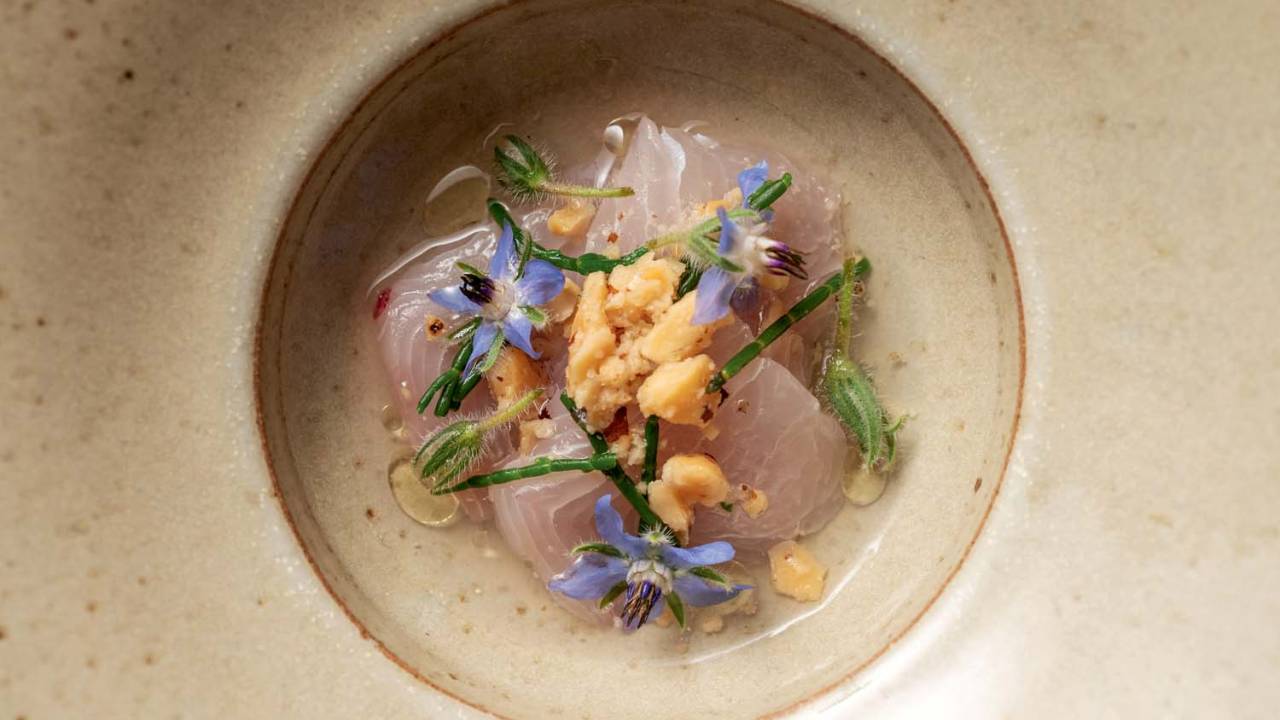 Foto aérea de peixe branco cru com flores lilás.